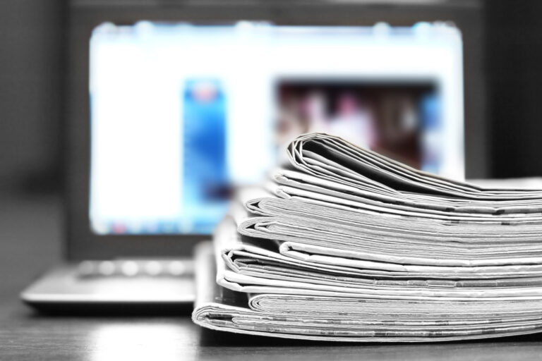 Newspapers and Laptop. Magazines Stacked on Computer. Tabloid Journals and Open Notebook - Information and News on Paper Pages or on Device Screen by Internet